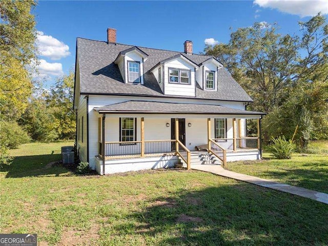 view of front of home featuring a front lawn, a porch, and central air condition unit