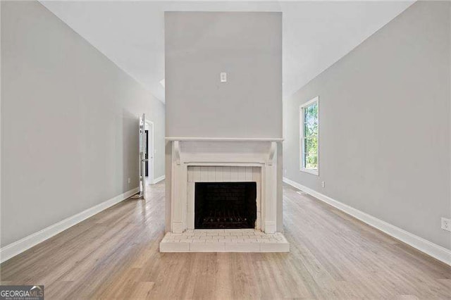 unfurnished living room featuring a fireplace and light hardwood / wood-style floors