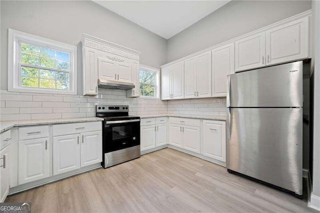 kitchen featuring decorative backsplash, white cabinets, appliances with stainless steel finishes, and plenty of natural light