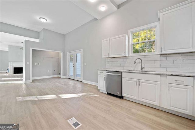 kitchen with dishwasher, white cabinetry, french doors, sink, and backsplash