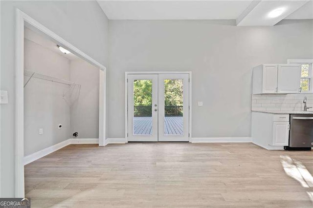 unfurnished living room featuring french doors and light hardwood / wood-style flooring