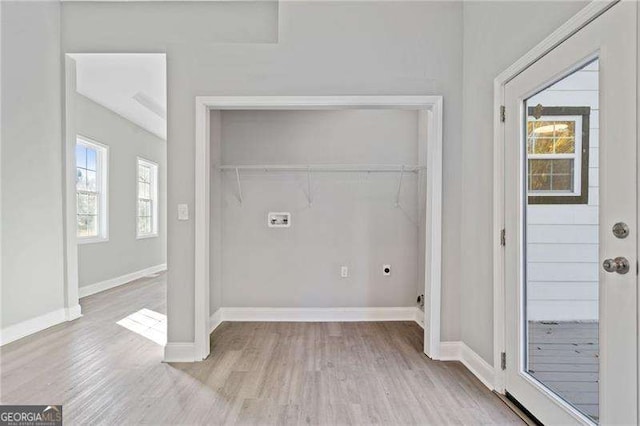 washroom with a healthy amount of sunlight, hookup for an electric dryer, and light hardwood / wood-style flooring