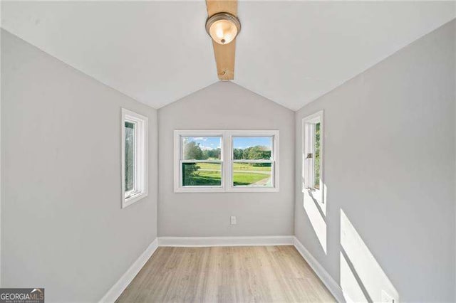 unfurnished room featuring light wood-type flooring and vaulted ceiling