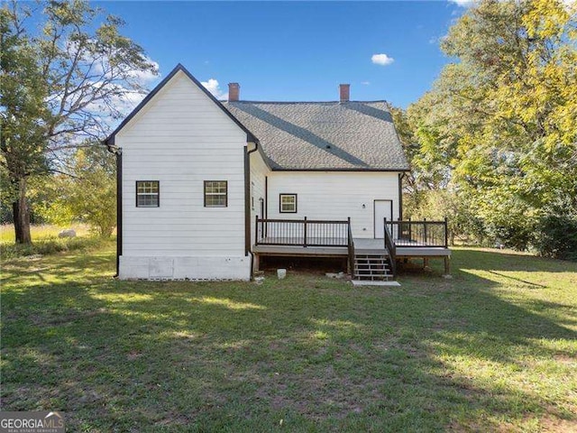 rear view of house with a deck and a lawn