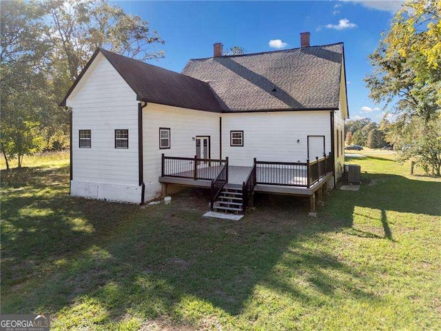 back of house featuring central AC unit, a wooden deck, and a yard