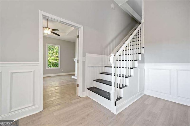 stairs with ceiling fan and hardwood / wood-style floors