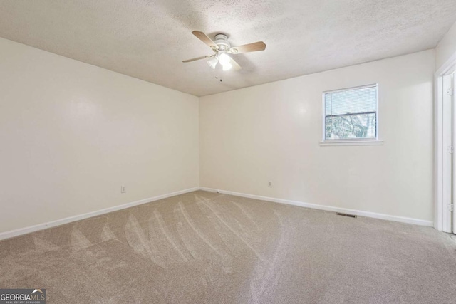 carpeted empty room featuring ceiling fan and a textured ceiling