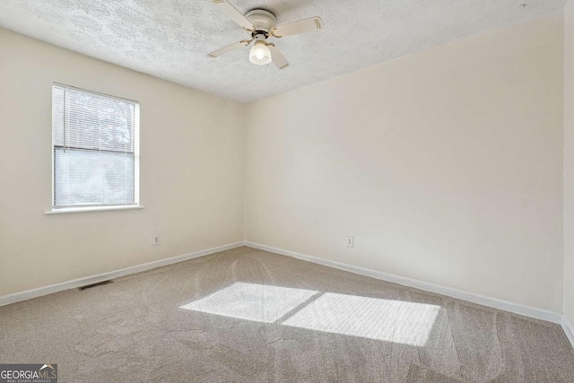 empty room with carpet, ceiling fan, and a textured ceiling