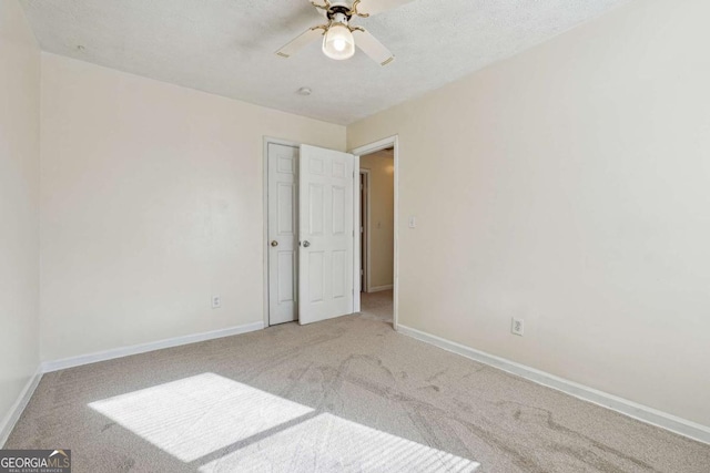 spare room featuring ceiling fan and carpet flooring