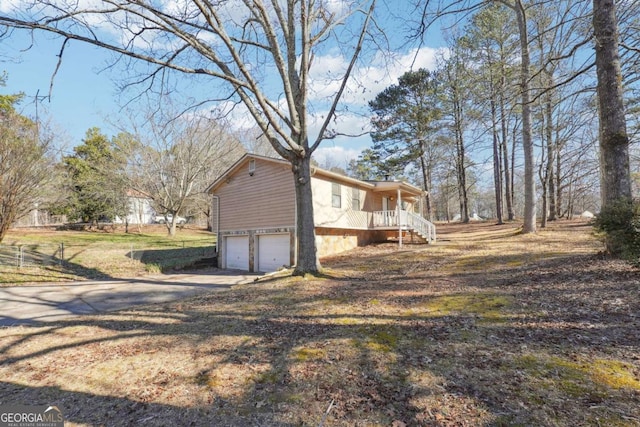 view of home's exterior with a garage and a porch