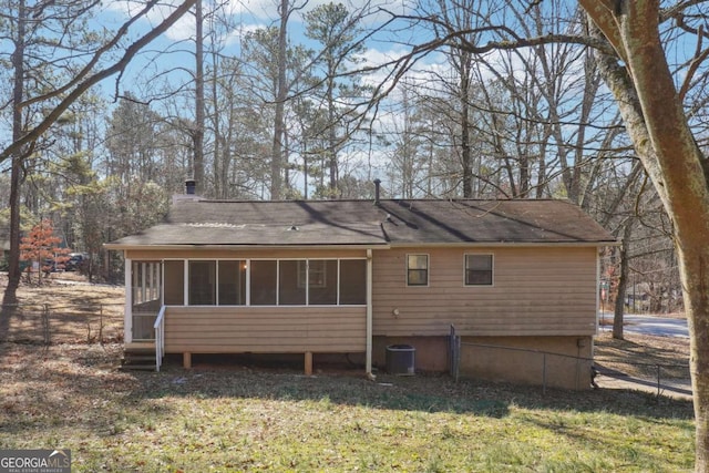 rear view of property with a sunroom, a lawn, and central air condition unit