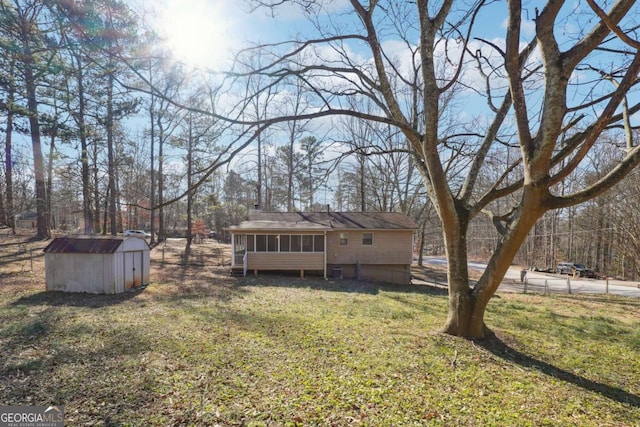 view of yard with a sunroom and a storage shed