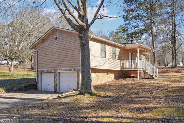 view of property exterior with a porch and a garage