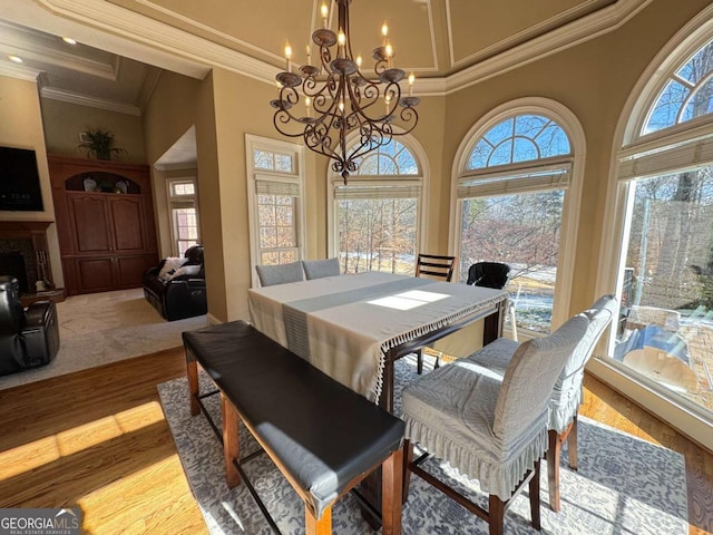 dining room with plenty of natural light, a chandelier, ornamental molding, and a high ceiling