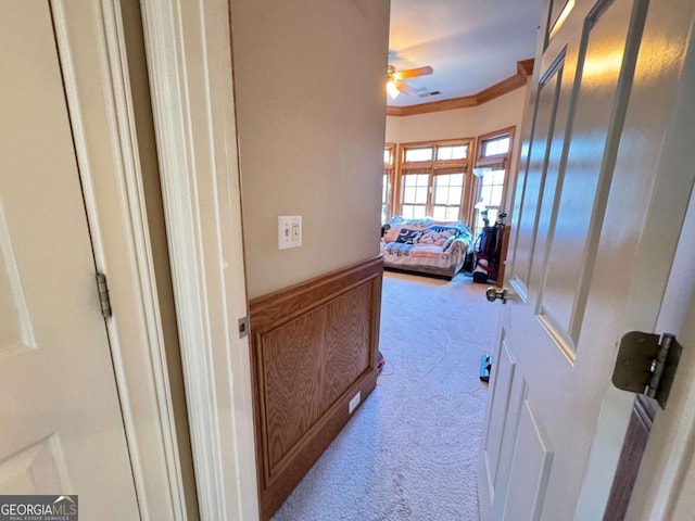 hall featuring crown molding and light colored carpet