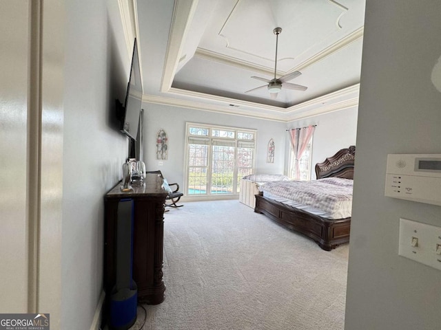 carpeted bedroom featuring a raised ceiling, ceiling fan, and ornamental molding