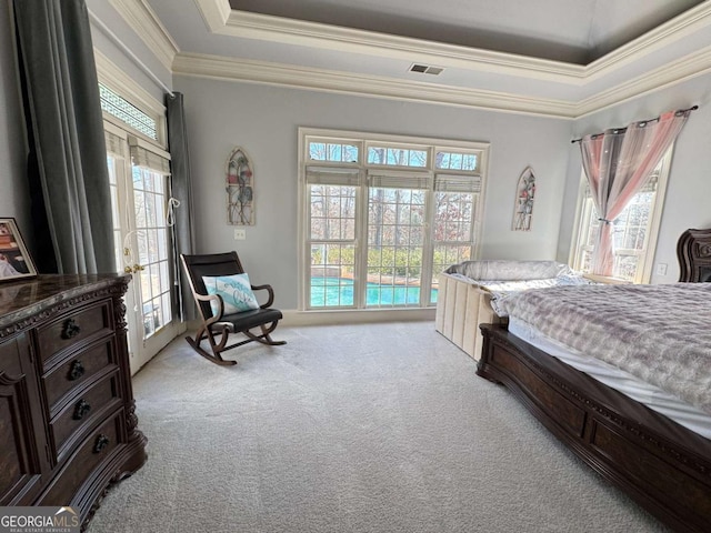 carpeted bedroom featuring a tray ceiling, multiple windows, and ornamental molding