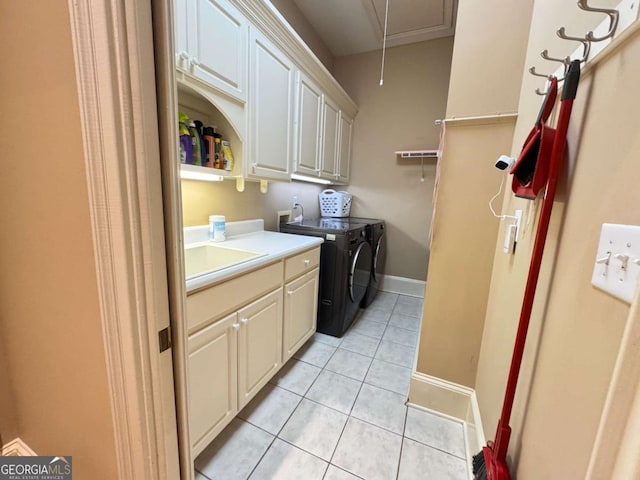 clothes washing area with cabinets, light tile patterned flooring, independent washer and dryer, and sink