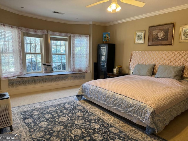 bedroom with ceiling fan, carpet, and crown molding