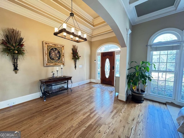 entryway with wood-type flooring and crown molding