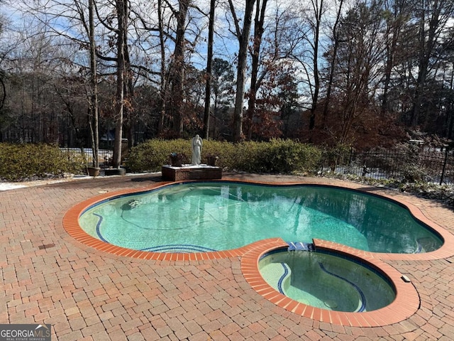 view of pool with an in ground hot tub