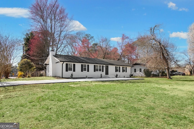 view of front of home with a chimney and a front lawn