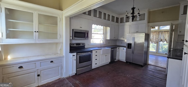 kitchen with hanging light fixtures, appliances with stainless steel finishes, and white cabinetry