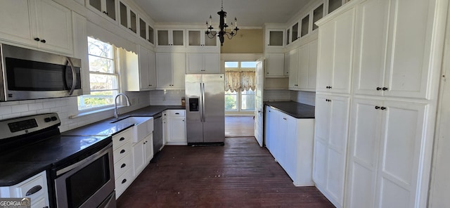 kitchen featuring plenty of natural light, stainless steel appliances, pendant lighting, and white cabinetry