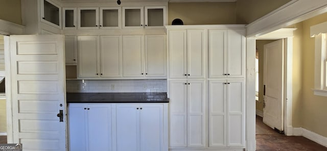 kitchen with tasteful backsplash and white cabinetry