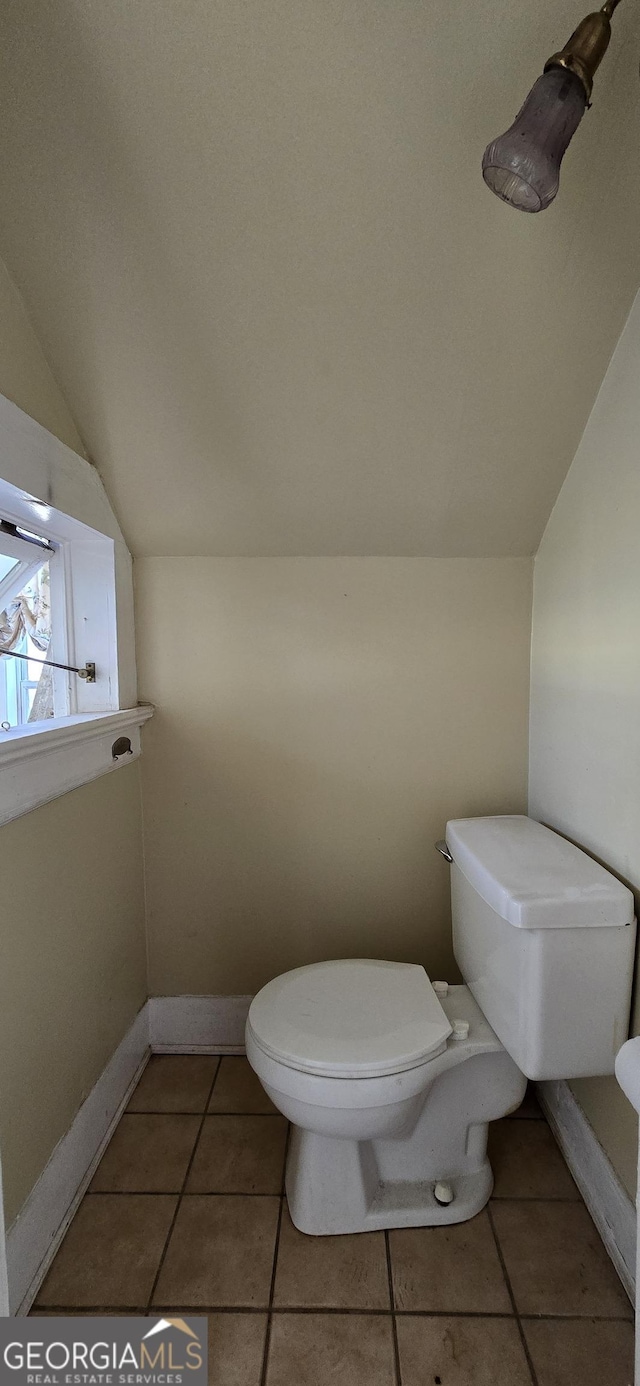 bathroom with toilet, tile patterned flooring, and vaulted ceiling