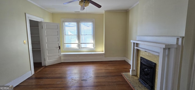 unfurnished living room featuring ceiling fan, dark wood-type flooring, and crown molding