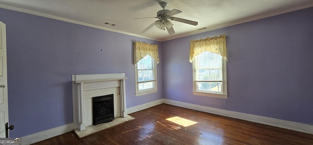 unfurnished living room featuring ceiling fan, dark wood-type flooring, ornamental molding, and a brick fireplace