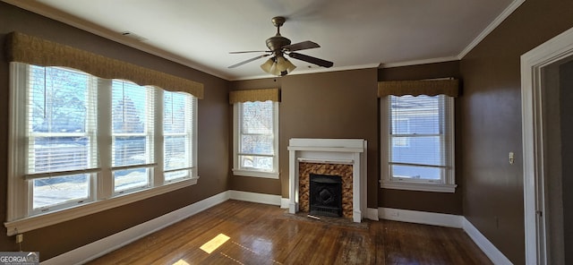 unfurnished living room with ceiling fan, dark hardwood / wood-style flooring, ornamental molding, and a wealth of natural light