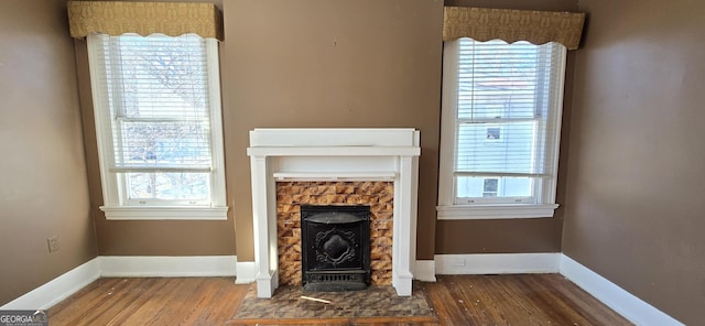 unfurnished living room with plenty of natural light, a wood stove, and dark hardwood / wood-style floors