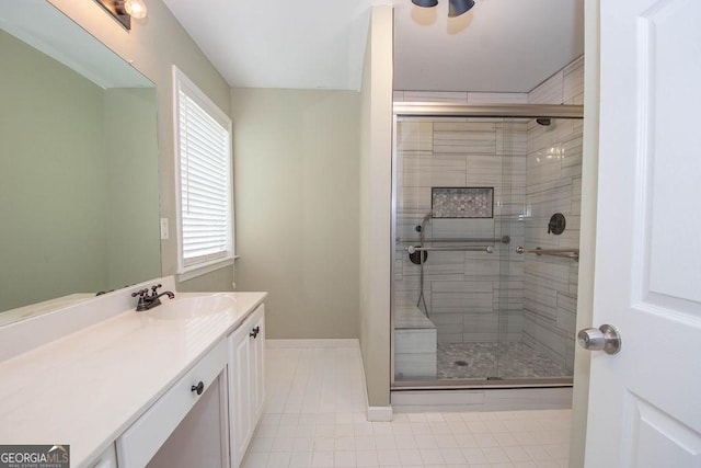 bathroom with tile patterned flooring, a shower with door, and vanity