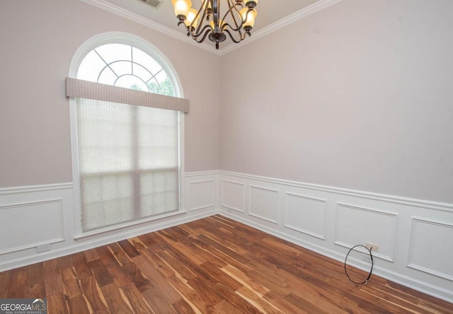 empty room featuring dark wood-type flooring, an inviting chandelier, and ornamental molding