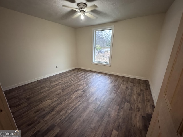 spare room featuring ceiling fan, dark hardwood / wood-style floors, and a textured ceiling