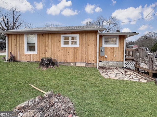 rear view of house featuring a deck and a yard