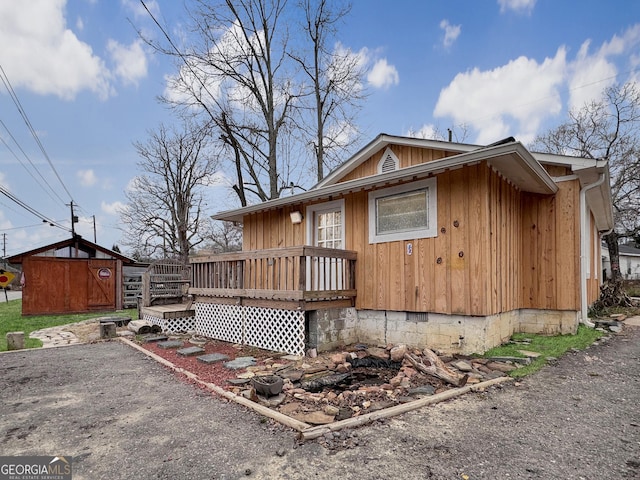 exterior space with a wooden deck and a storage unit