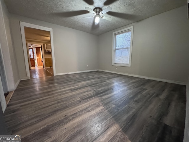 empty room with dark wood-type flooring, ceiling fan, and a textured ceiling