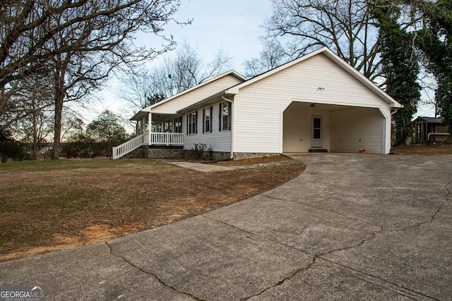 ranch-style home with covered porch, a front yard, and a carport