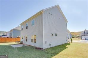 back of house with a yard and a patio