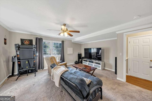 living area featuring light colored carpet, crown molding, baseboards, and ceiling fan