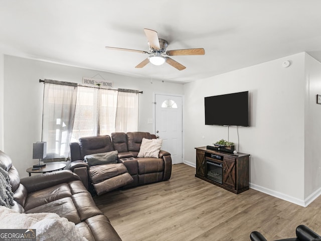 living room featuring ceiling fan and light hardwood / wood-style floors