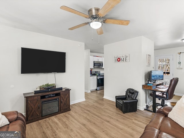 living room with ceiling fan and light hardwood / wood-style flooring