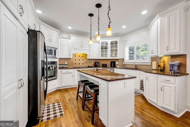 kitchen with white cabinets, a breakfast bar area, stainless steel appliances, and a sink