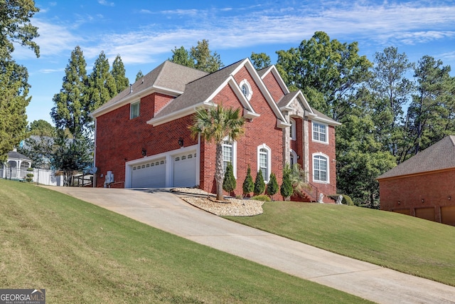 colonial inspired home with a front yard, brick siding, driveway, and fence