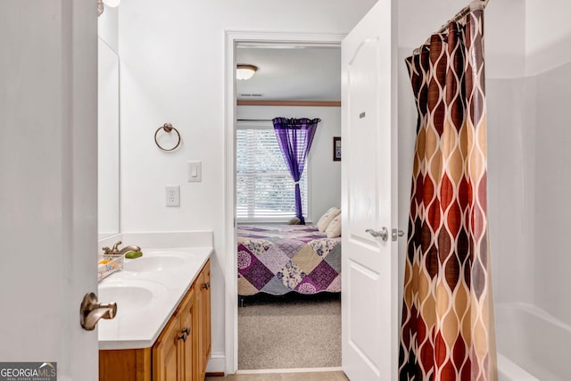 full bathroom featuring double vanity, ensuite bath, a sink, and crown molding