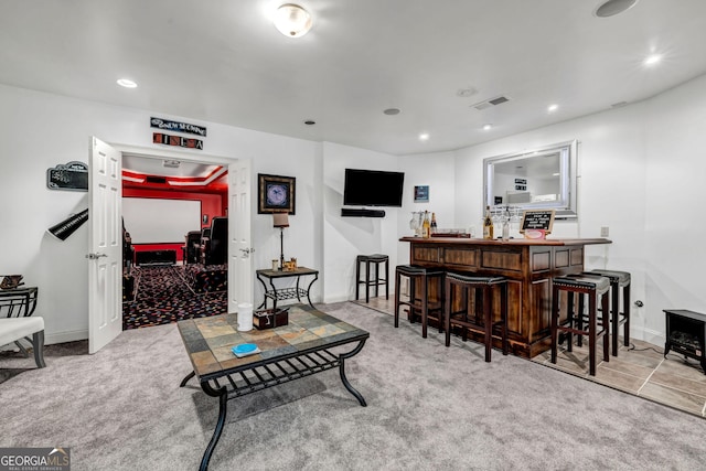 carpeted living area with baseboards, a bar, visible vents, and recessed lighting