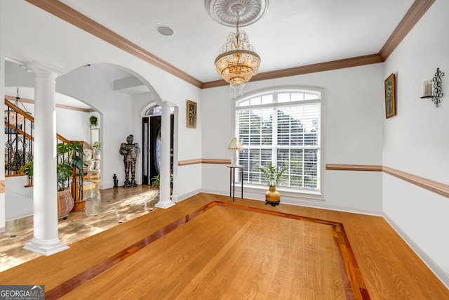 unfurnished dining area featuring decorative columns, arched walkways, and wood finished floors